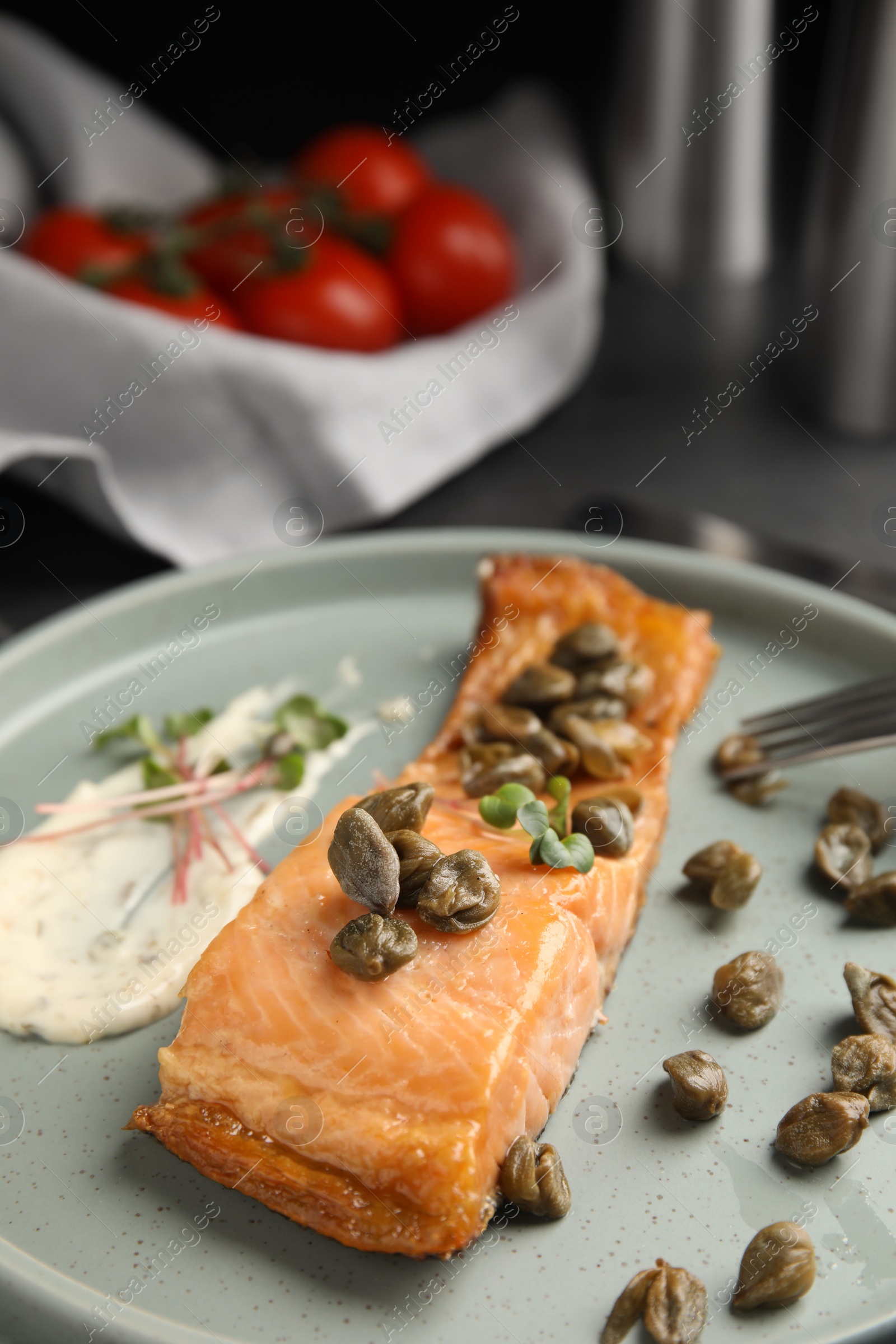 Photo of Delicious salmon with capers and sauce on plate, closeup