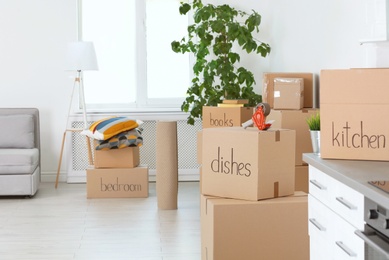 Photo of Moving boxes and household stuff indoors. Space for text