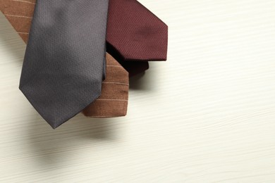 Photo of Different neckties on white wooden table, top view. Space for text