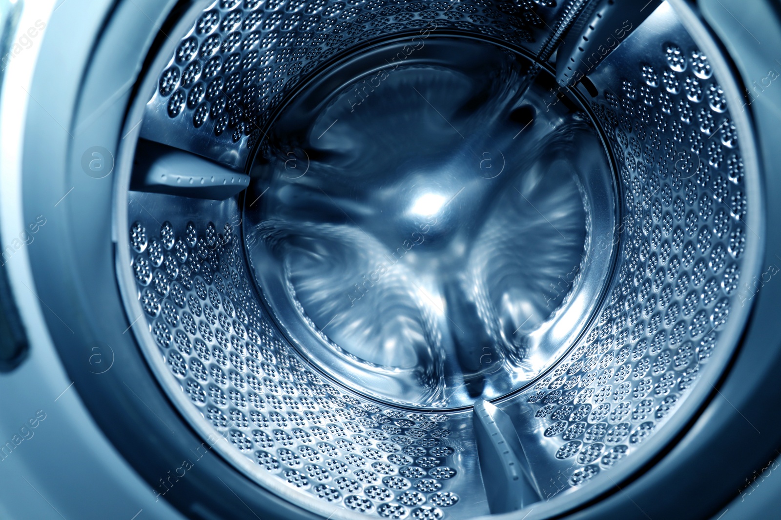 Photo of Empty washing machine drum, closeup. Laundry day