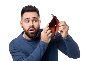 Confused man showing empty wallet on white background