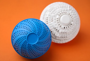 Photo of Dryer balls for washing machine on orange background. Laundry detergent substitute