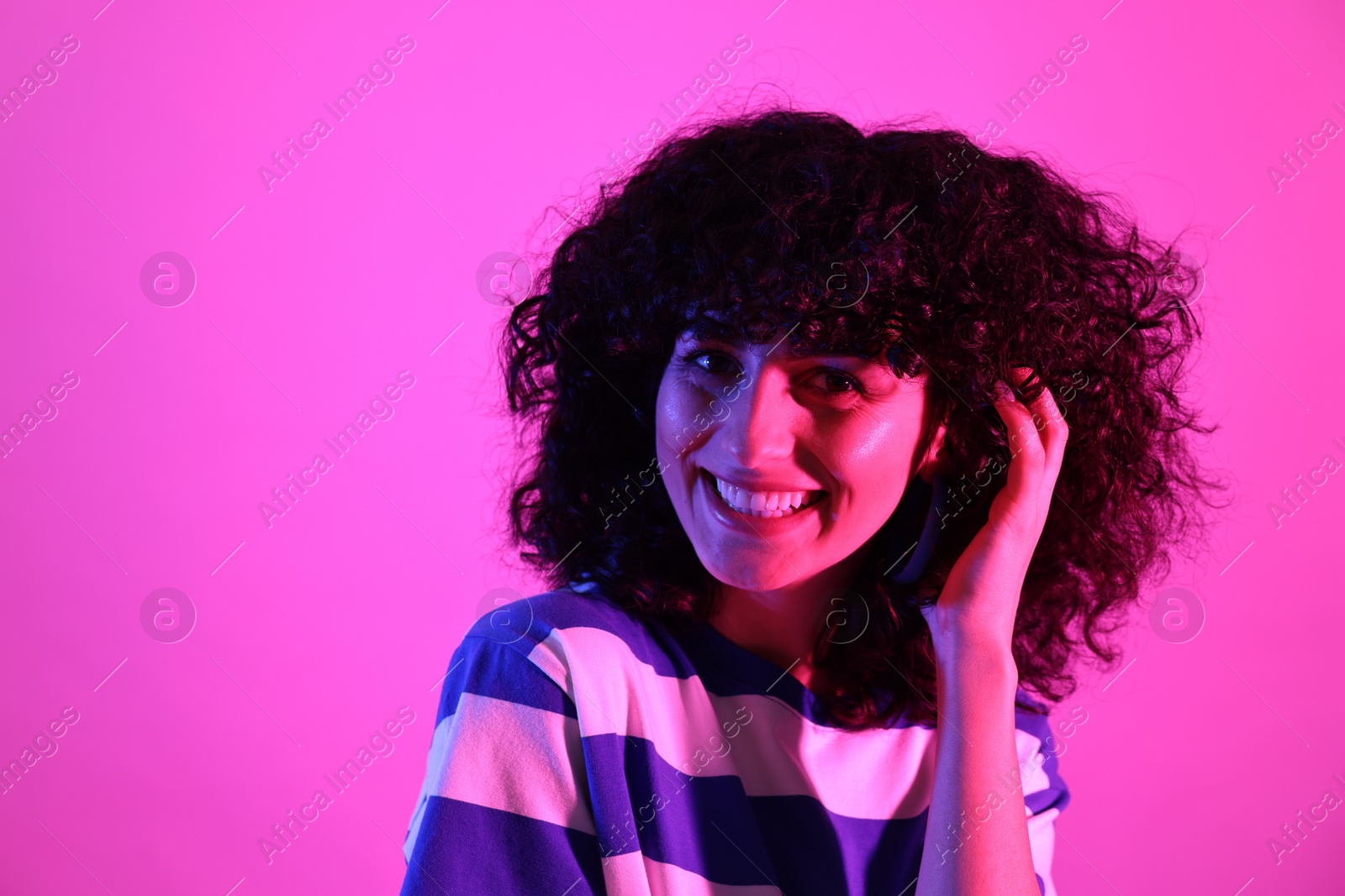 Photo of Beautiful young woman posing on color background in neon lights