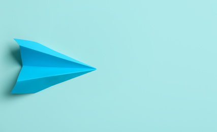 Paper plane on light blue background, top view. Space for text