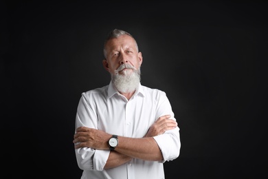 Portrait of handsome senior man on black background