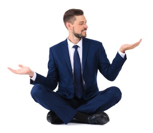 Photo of Businessman sitting in lotus position and showing balance gesture on white background
