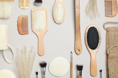 Photo of Flat lay composition with modern hair combs and brushes on light background