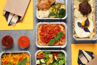 Lunchboxes on grey table, flat lay. Healthy food delivery