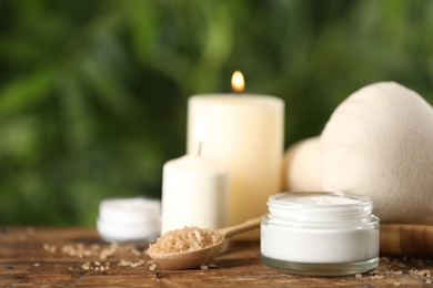 Photo of Beautiful spa composition with cream and candles on wooden table, closeup