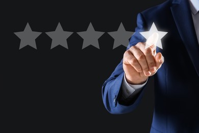 Man choosing one star out of five on virtual screen against black background, closeup. Customer satisfaction score