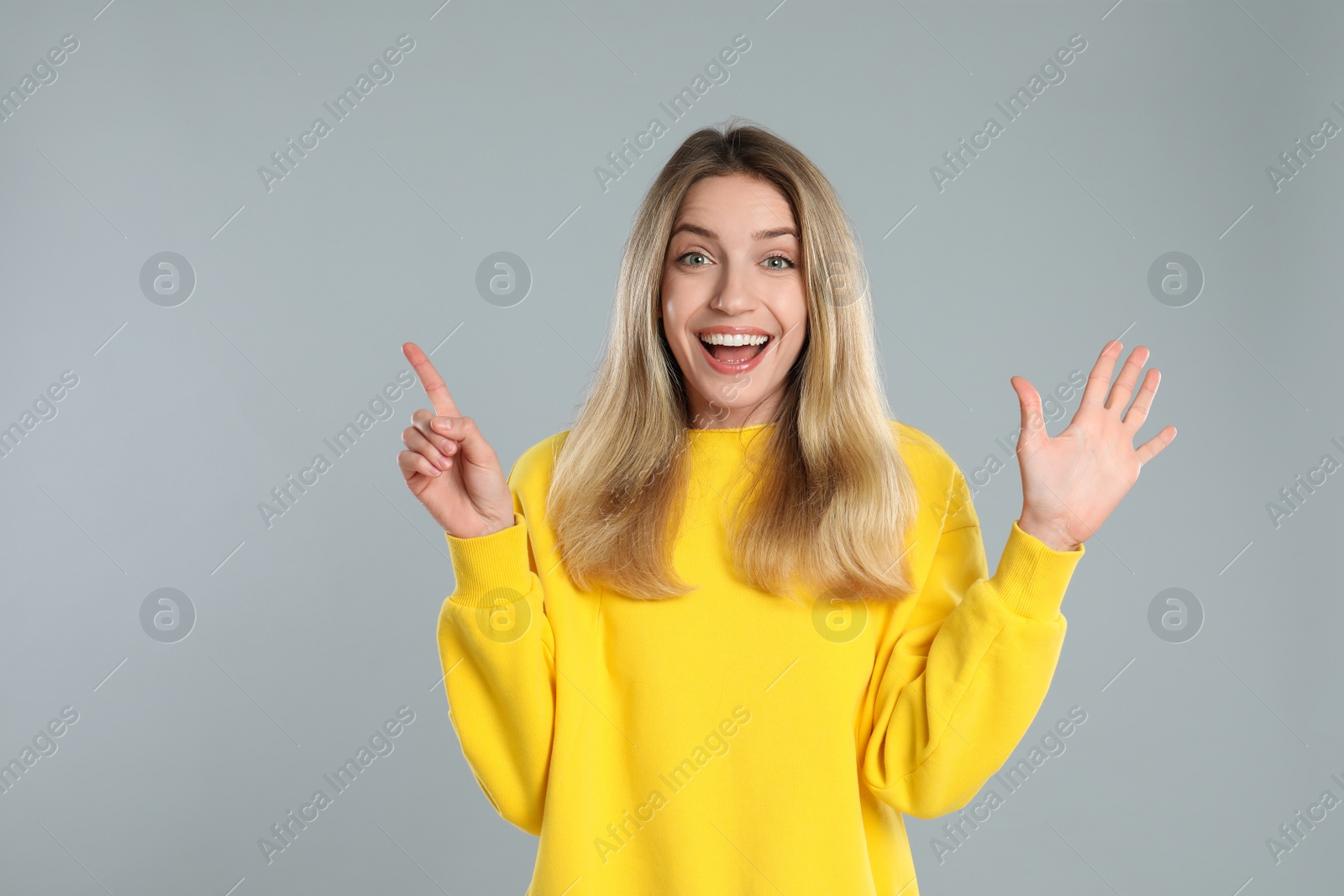 Photo of Woman showing number six with her hands on light grey background