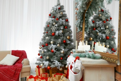 Photo of Stylish interior with beautiful Christmas tree and decorative fireplace