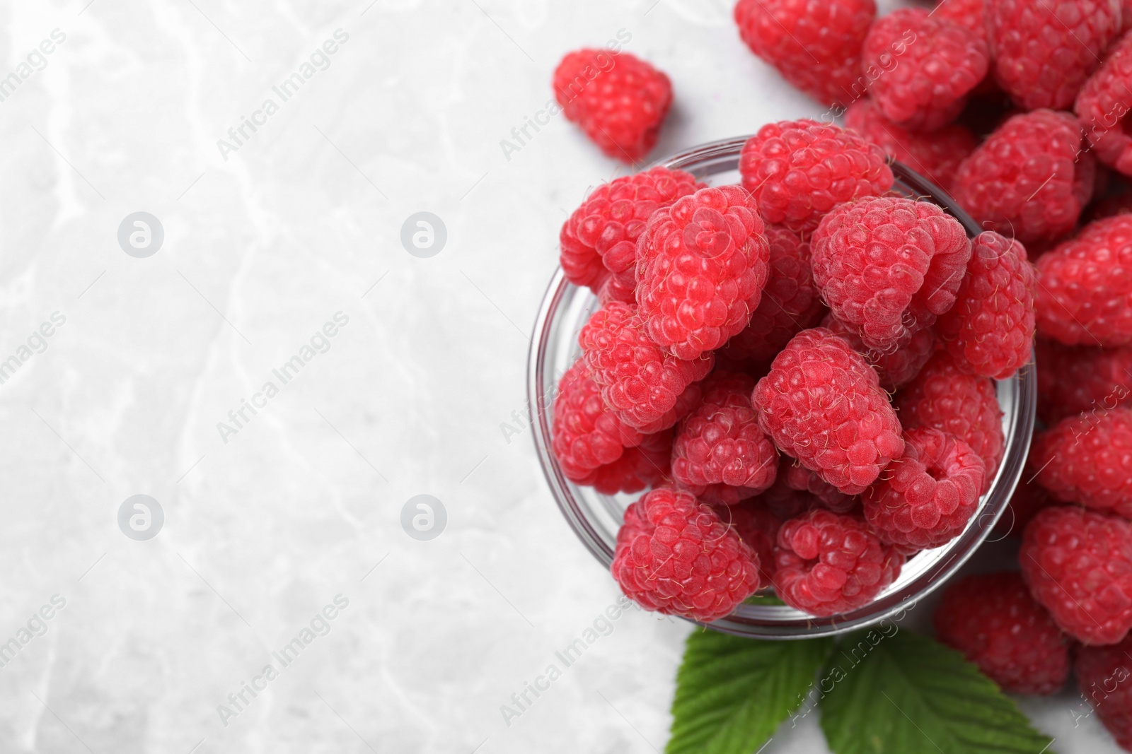 Photo of Delicious fresh ripe raspberries on light grey table, flat lay. Space for text