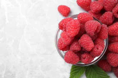 Photo of Delicious fresh ripe raspberries on light grey table, flat lay. Space for text