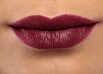 Photo of Young woman wearing dark lipstick, closeup view