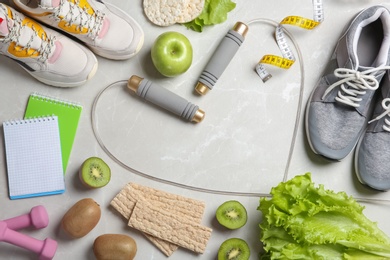 Photo of Flat lay composition with sport items, healthy food and space for text on grey background. Weight loss concept