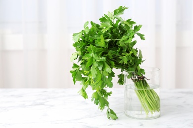 Jar with fresh green parsley on table