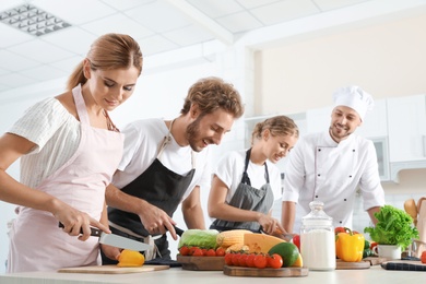 Photo of Group of people and male chef at cooking classes