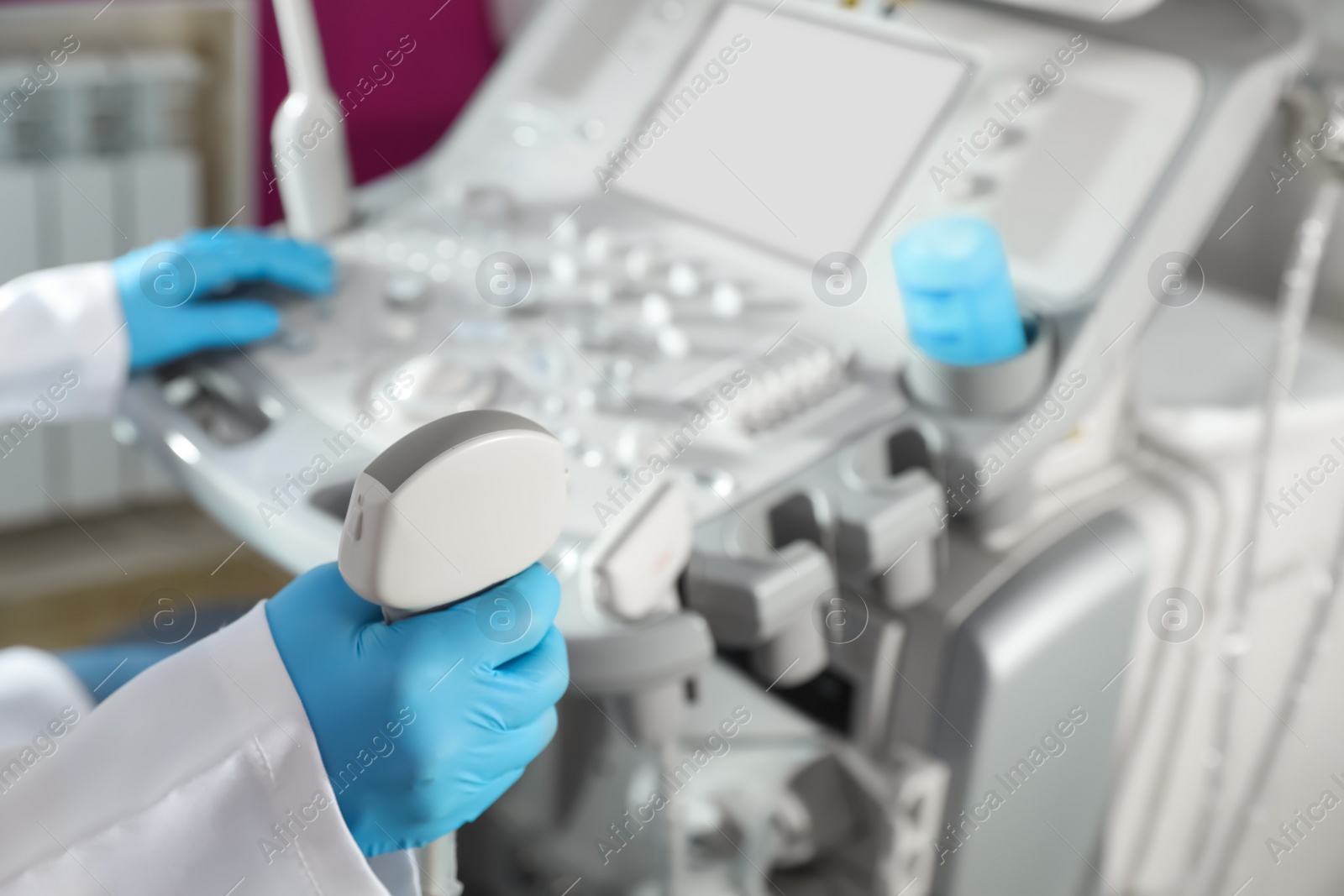 Photo of Sonographer holding ultrasound machine probe in clinic, closeup with space for text