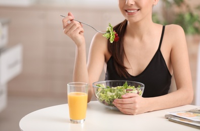 Photo of Young woman in fitness clothes having healthy breakfast at home, closeup