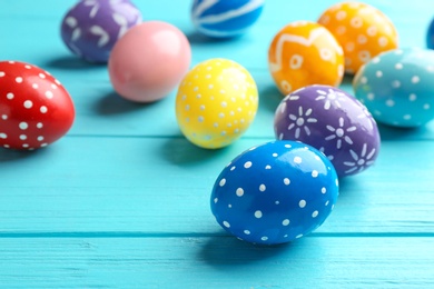 Photo of Painted Easter eggs on wooden table, space for text