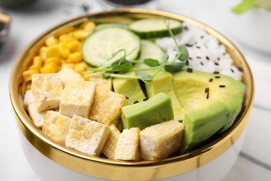 Photo of Delicious poke bowl with vegetables, tofu, avocado and microgreens, closeup