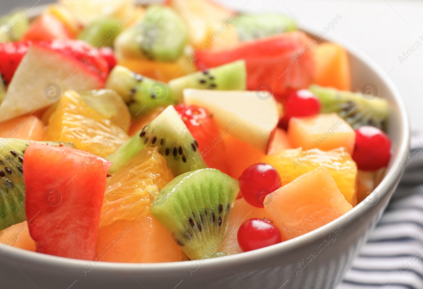 Photo of Bowl with fresh cut fruits, closeup