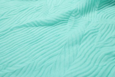 Photo of Texture of turquoise crumpled fabric as background, closeup