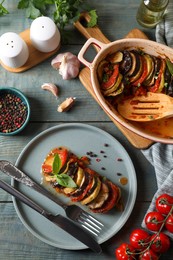 Delicious ratatouille served with basil on grey wooden table, flat lay
