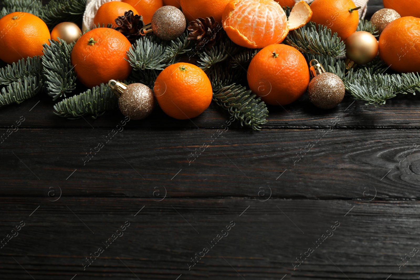 Photo of Christmas composition with fresh tangerines and fir tree branches on dark wooden table, space for text