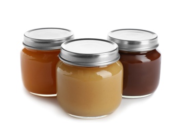 Jars with healthy baby food on white background