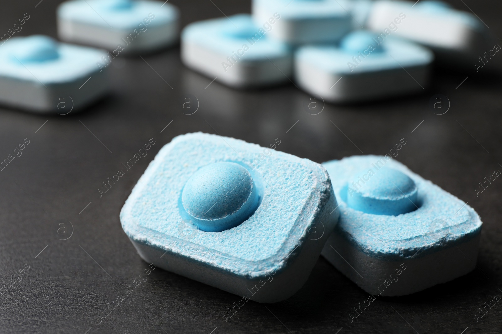 Photo of Water softener tablets on grey table, closeup