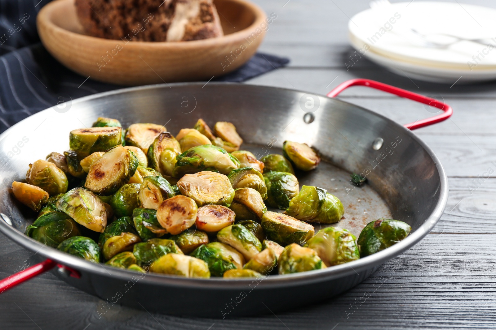 Photo of Delicious roasted brussels sprouts on grey wooden table, closeup