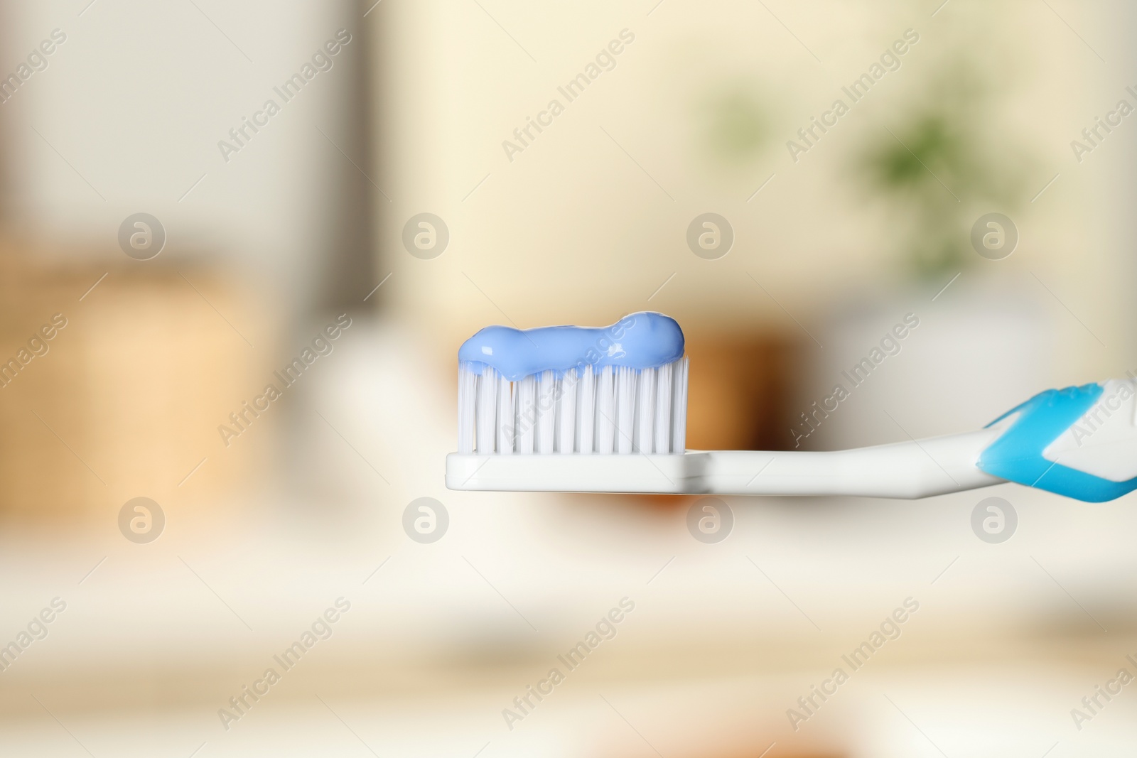 Photo of Plastic toothbrush with paste on blurred background, closeup