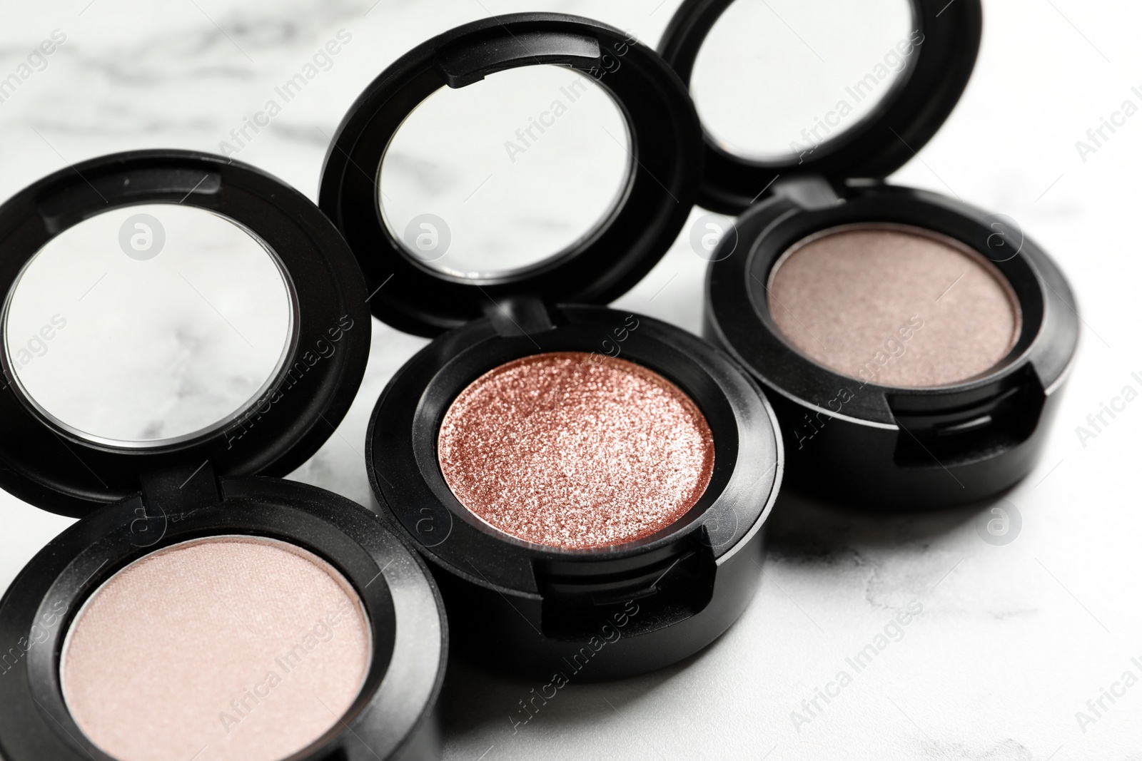 Photo of Different eye shadows on marble table, closeup