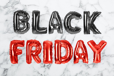 Image of Phrase BLACK FRIDAY made of foil balloon letters on white marble background