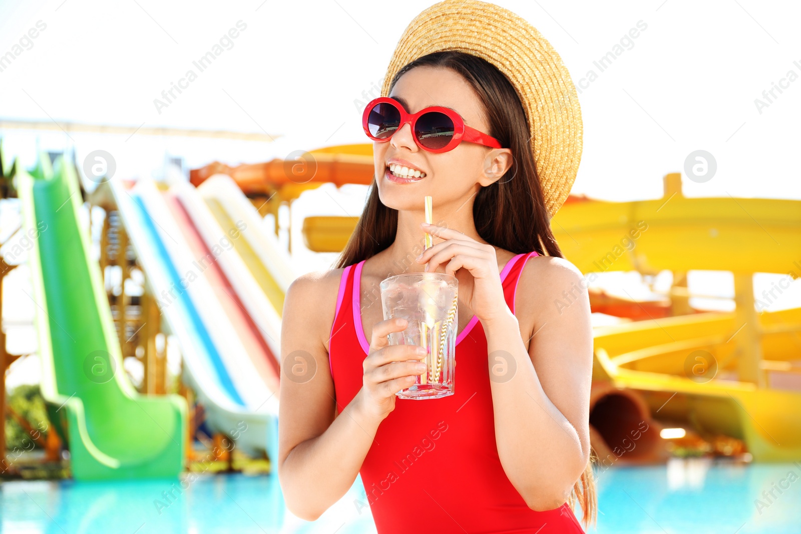 Photo of Woman with glass of refreshing drink in water park