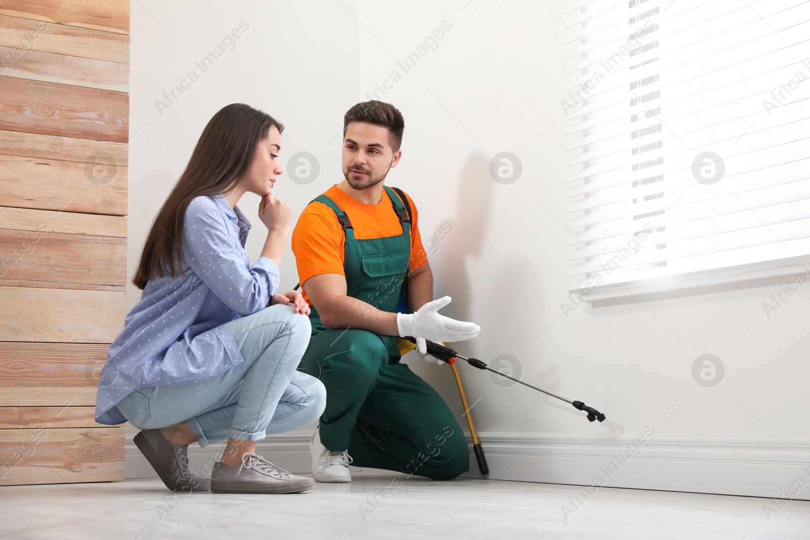 Photo of Woman showing insect traces to pest control worker at home