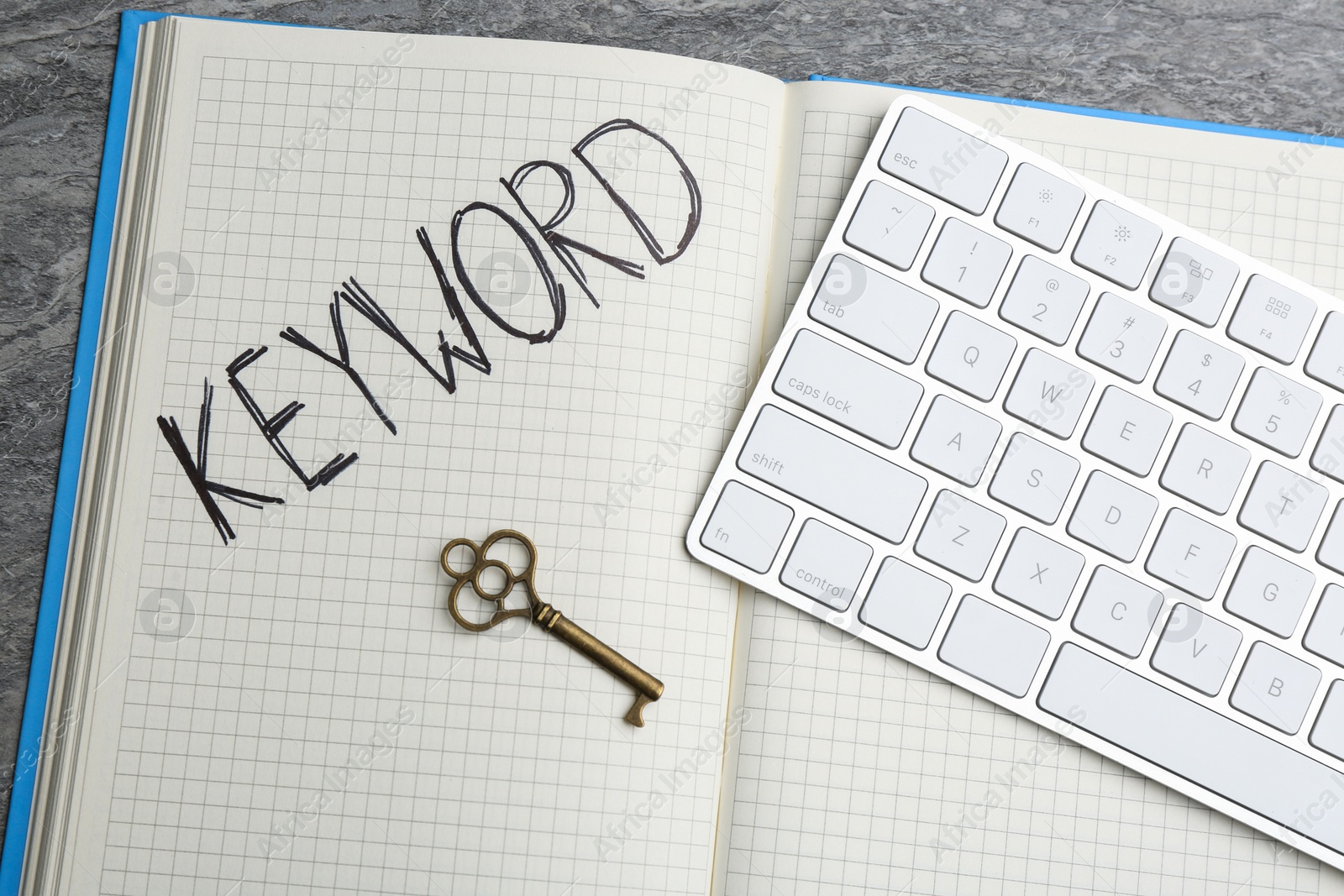 Photo of Key, notebook and computer keyboard on table, flat lay. Keyword concept