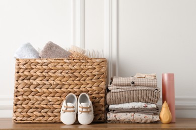 Baby clothes, shoes and accessories on wooden table