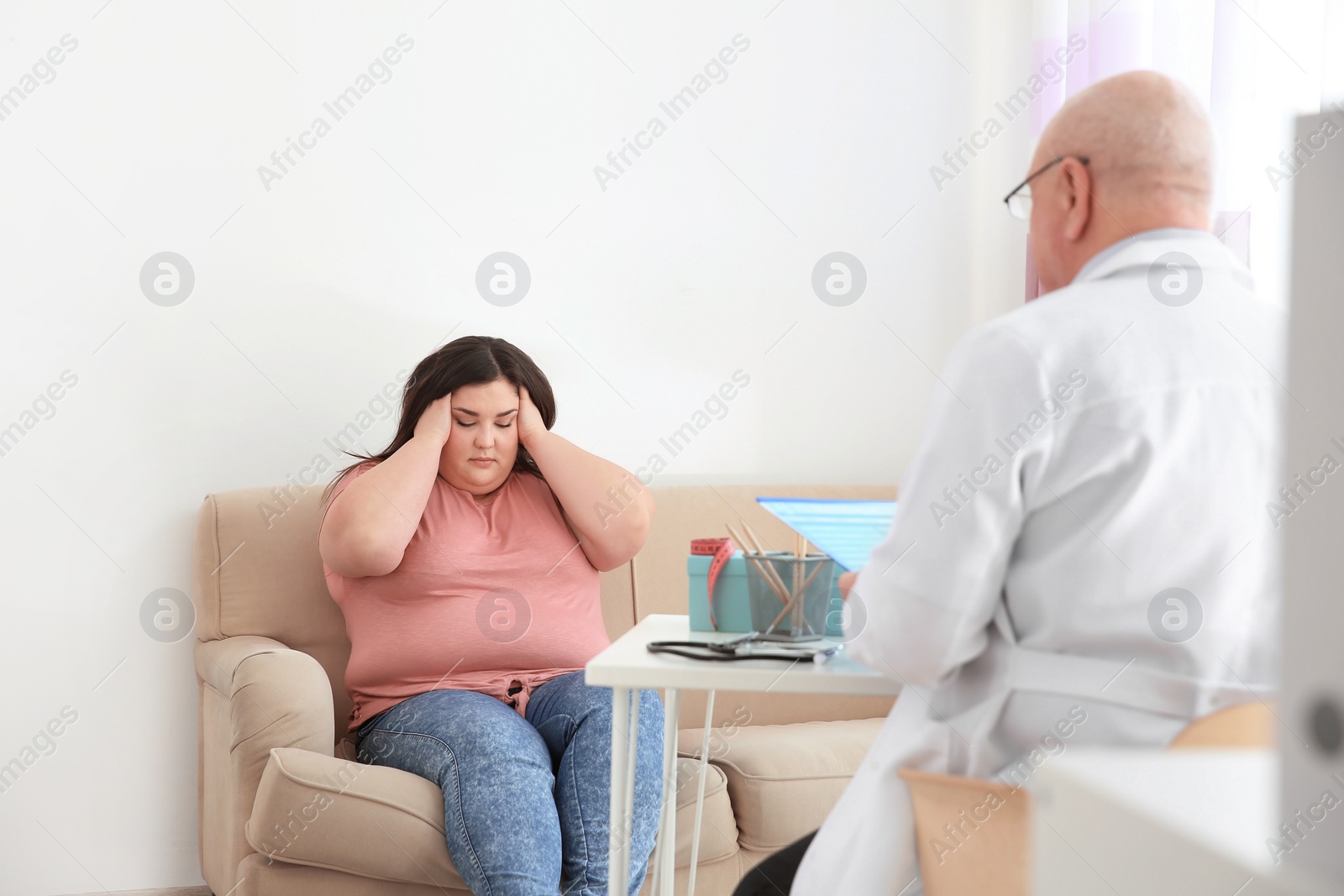 Photo of Emotional overweight woman having consultation at doctor's office