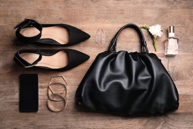 Photo of Flat lay composition with stylish shoes, woman's bag and smartphone on wooden background