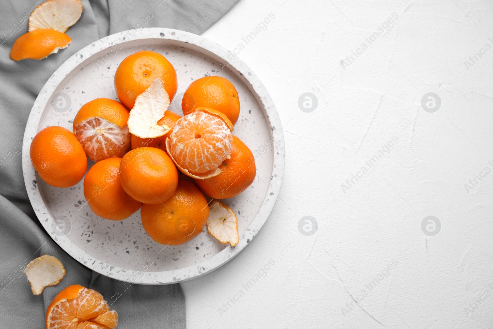 Photo of Fresh ripe tangerines on white table, top view. Space for text