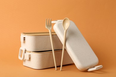 Photo of Lunch boxes and cutlery on orange background. Conscious consumption