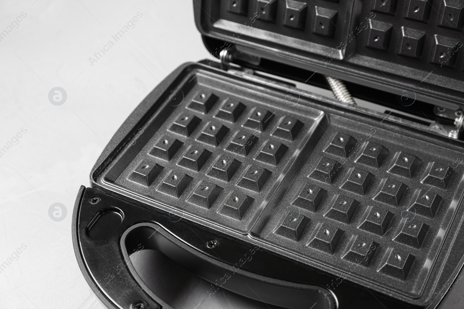 Photo of Modern waffle iron on white table, closeup