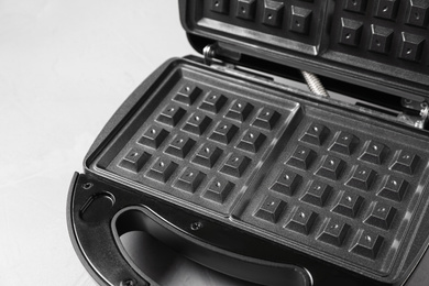 Photo of Modern waffle iron on white table, closeup