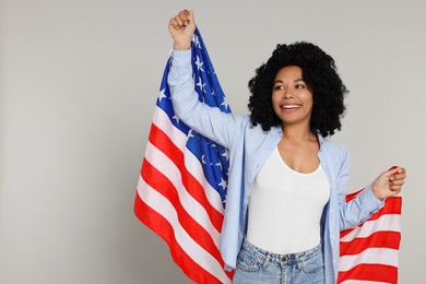 4th of July - Independence Day of USA. Happy woman with American flag on light grey background, space for text