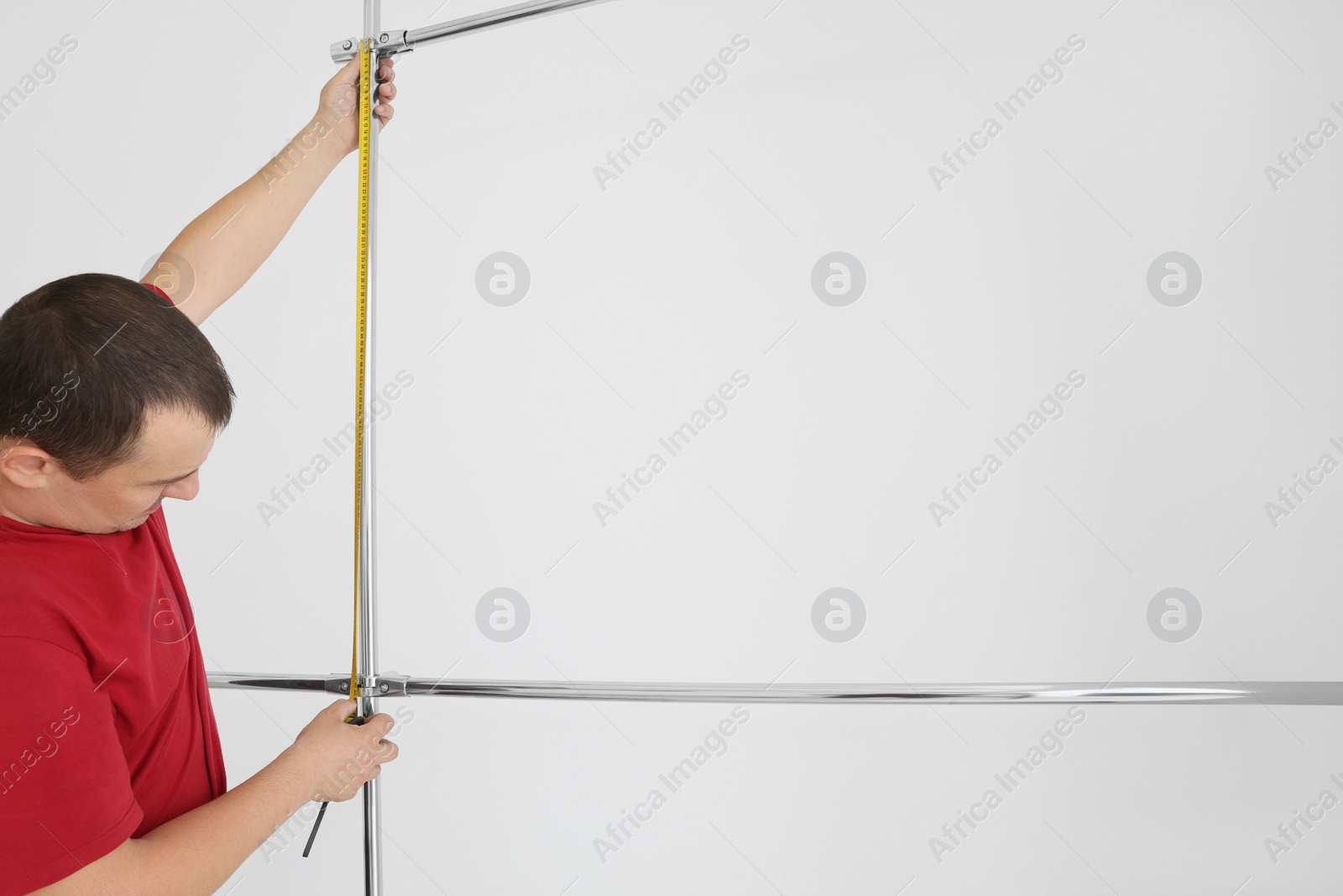 Photo of Worker measuring metal pipes for installation, closeup