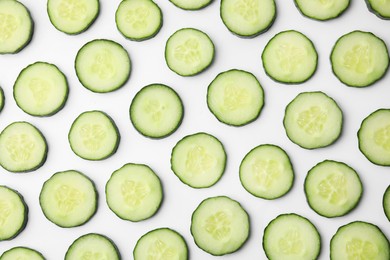 Photo of Fresh slices of cucumbers on white background, top view