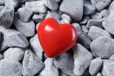 Photo of One red decorative heart on grey stones, above view